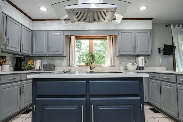 kitchen featuring gray cabinets, crown molding, light tile patterned floors, and tasteful backsplash