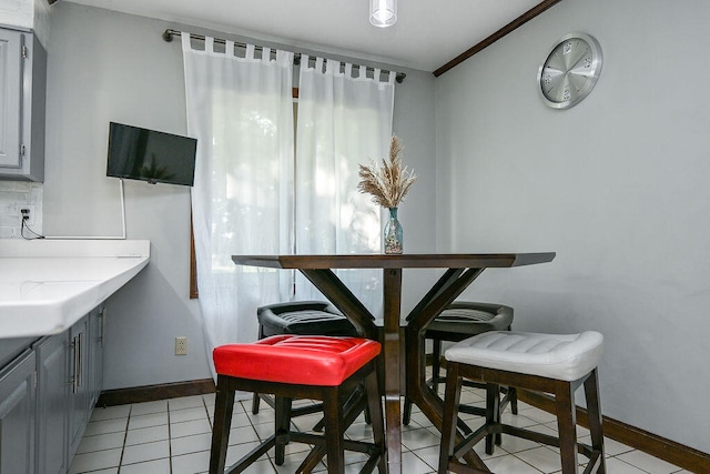 tiled dining area featuring ornamental molding