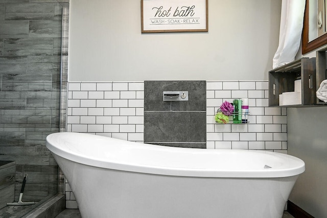 bathroom with shower with separate bathtub and tile walls