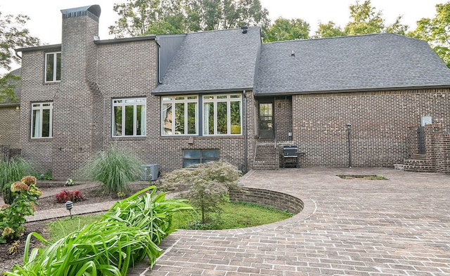 rear view of property featuring a patio and central AC