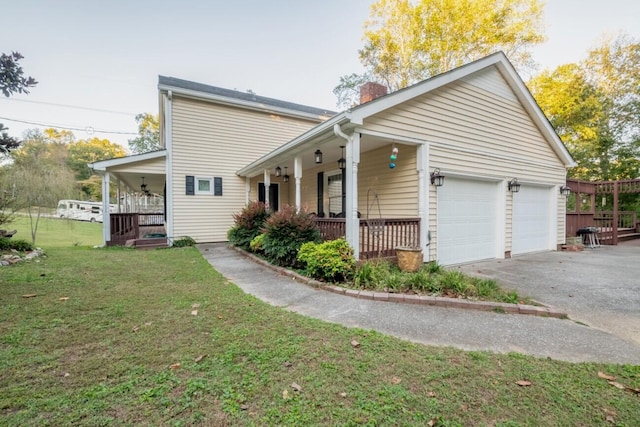 view of home's exterior with a porch, a garage, a yard, a chimney, and aphalt driveway