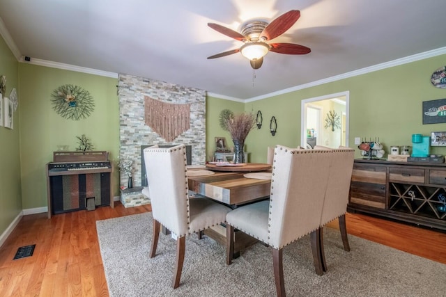 dining space with ornamental molding, hardwood / wood-style floors, and ceiling fan