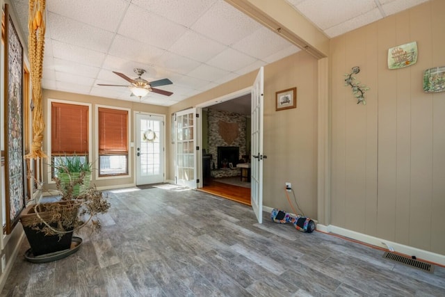 foyer with ceiling fan, hardwood / wood-style flooring, a fireplace, and a paneled ceiling