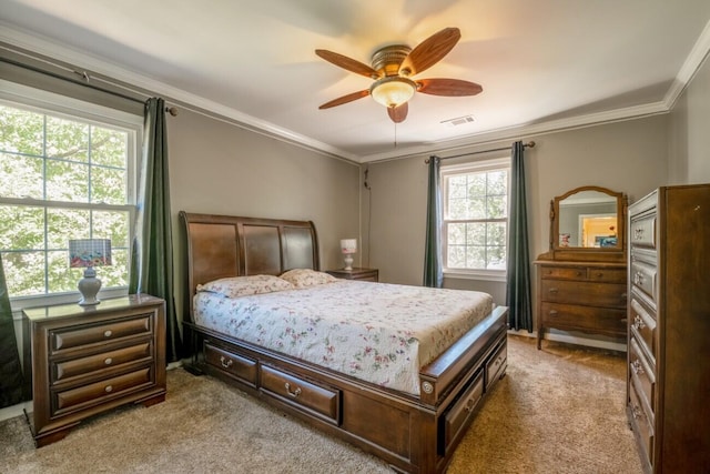 carpeted bedroom featuring visible vents, crown molding, and a ceiling fan