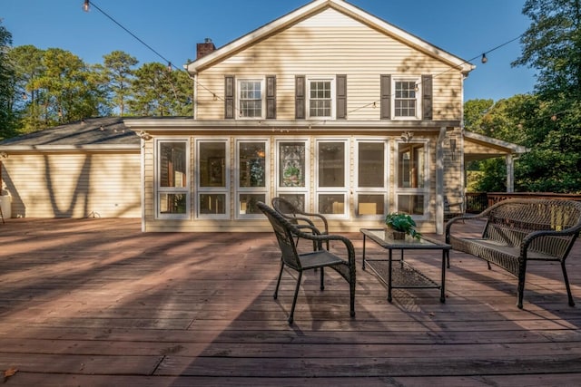 back of property featuring a deck and a sunroom