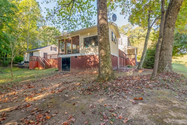 exterior space with a sunroom and a wooden deck