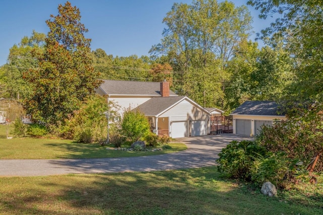view of front of home with a chimney, a front yard, concrete driveway, and an attached garage