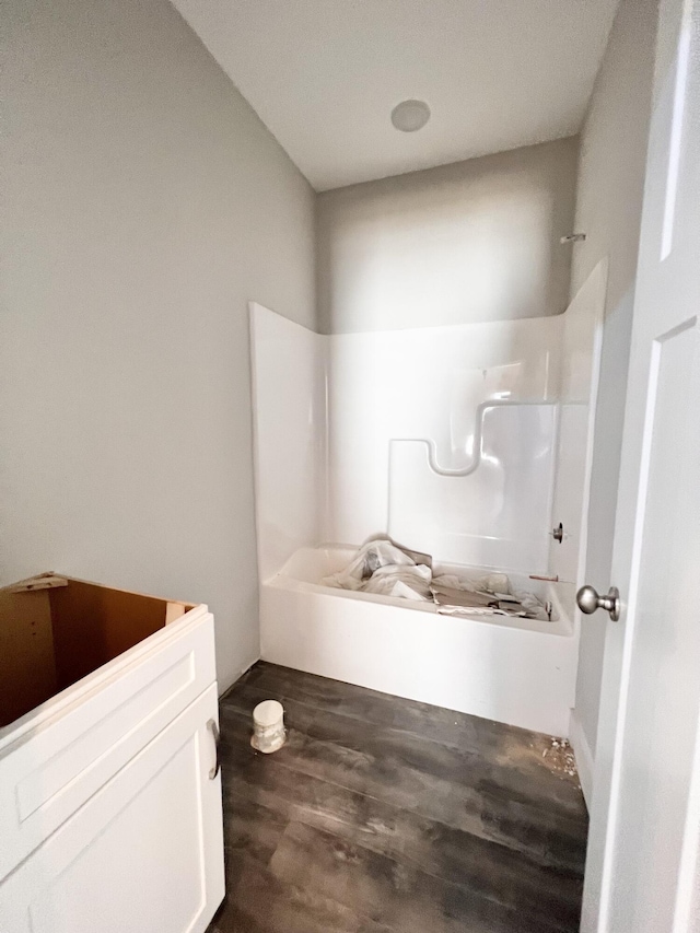 bathroom featuring wood-type flooring and  shower combination