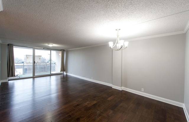 empty room with a notable chandelier, dark hardwood / wood-style flooring, ornamental molding, and a textured ceiling