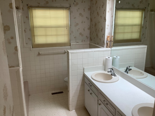 bathroom featuring vanity, tile walls, tile patterned flooring, and toilet