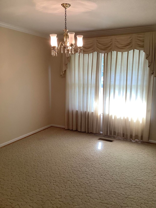 carpeted empty room with ornamental molding and an inviting chandelier