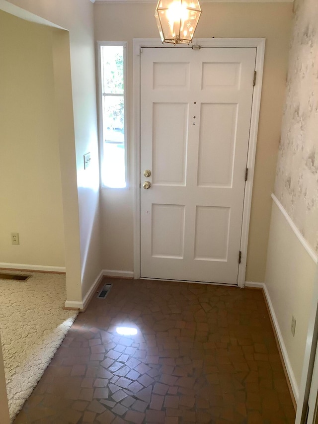 doorway to outside with an inviting chandelier