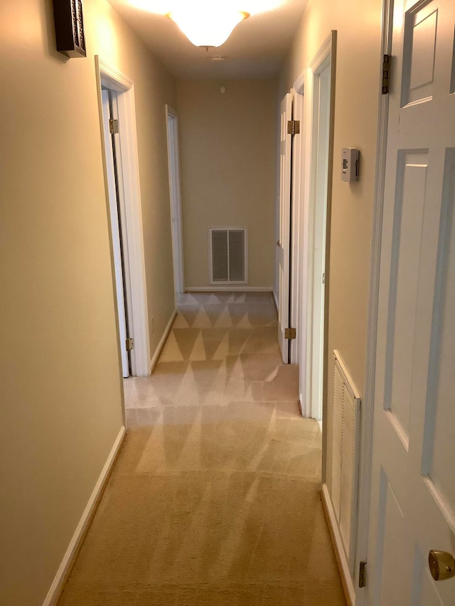 hall featuring light colored carpet