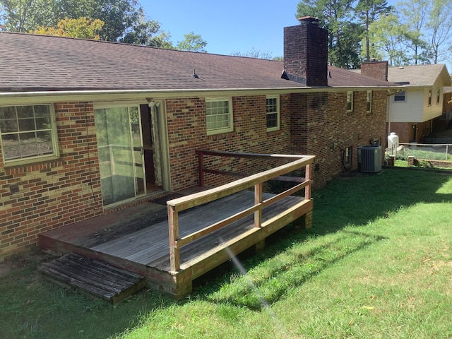 rear view of property with a deck, a yard, and central air condition unit