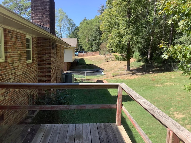 view of yard with a trampoline, a wooden deck, and central AC