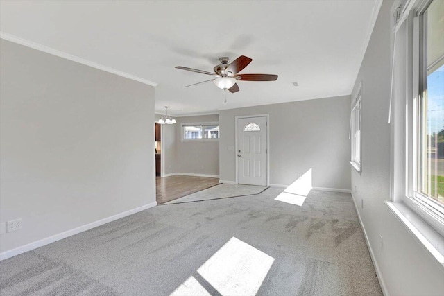 interior space with light colored carpet, ceiling fan with notable chandelier, and ornamental molding