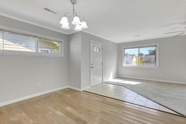 entrance foyer with ceiling fan with notable chandelier, light wood-type flooring, and crown molding