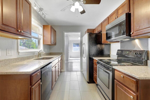 kitchen featuring ceiling fan, light tile patterned flooring, sink, appliances with stainless steel finishes, and light stone countertops