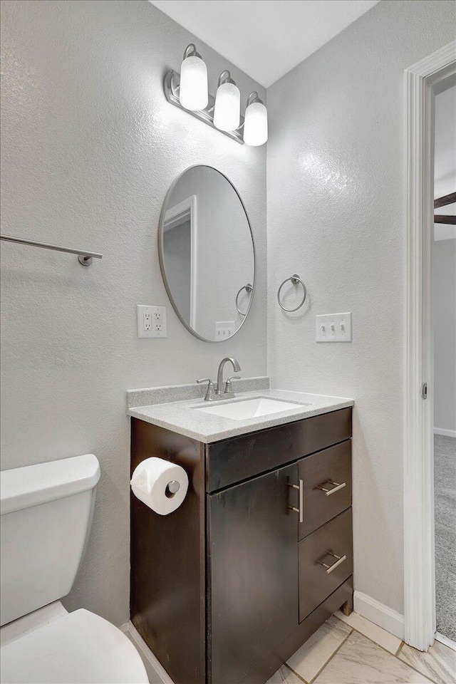 bathroom featuring vanity and toilet