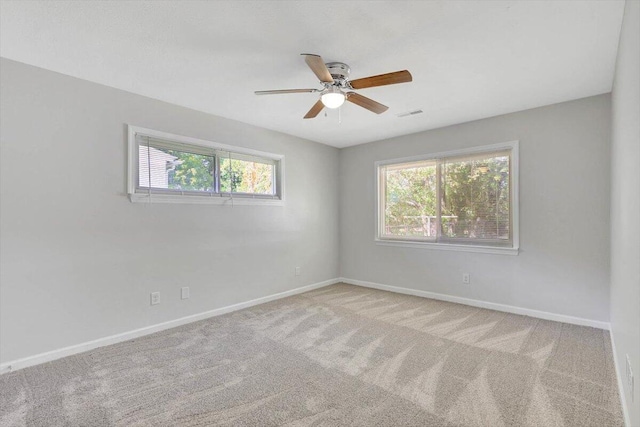 carpeted empty room featuring a healthy amount of sunlight and ceiling fan