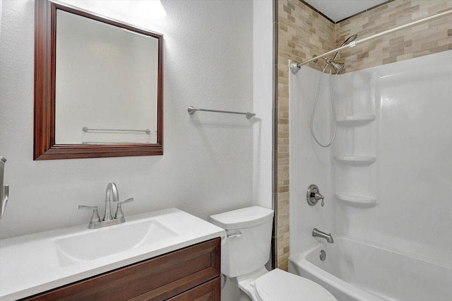 full bathroom featuring tiled shower / bath, vanity, and toilet