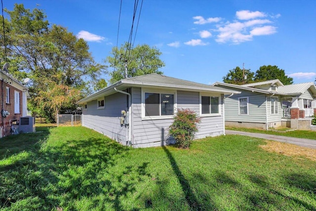 view of front of property with a front lawn and central AC unit