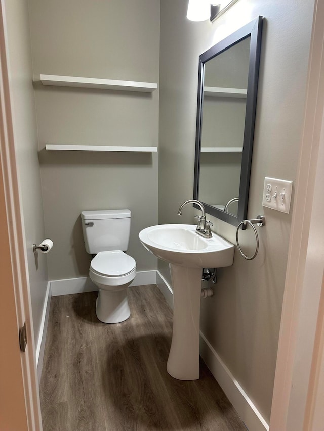 bathroom with hardwood / wood-style flooring and toilet