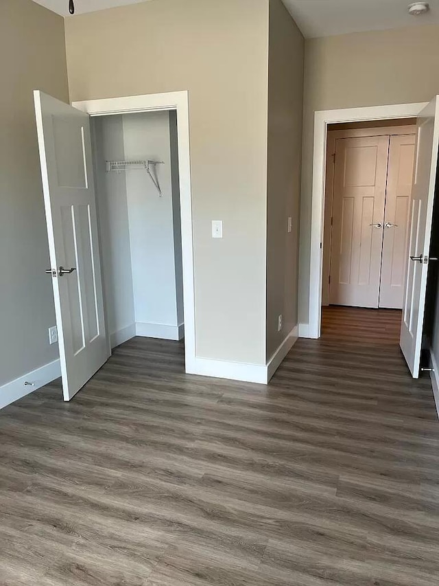 unfurnished bedroom with a closet and dark hardwood / wood-style floors