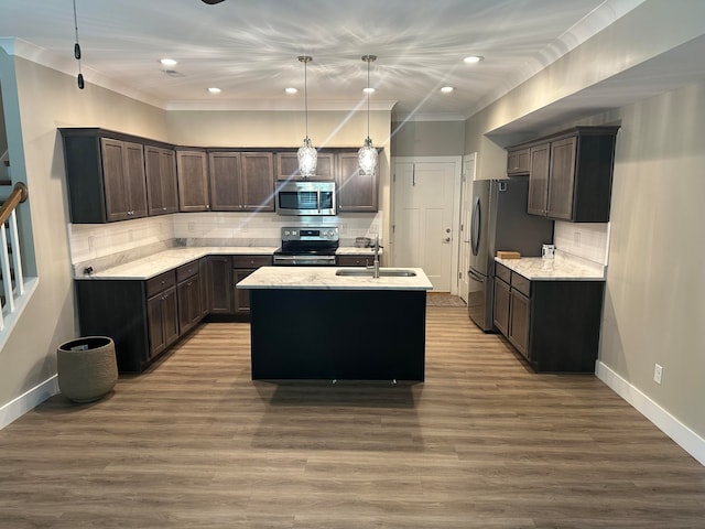 kitchen featuring a kitchen island with sink, dark hardwood / wood-style floors, sink, pendant lighting, and appliances with stainless steel finishes