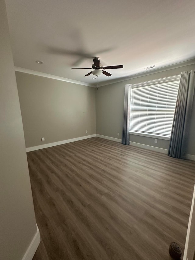 unfurnished room featuring ceiling fan, ornamental molding, and dark wood-type flooring