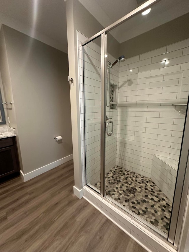 bathroom featuring wood-type flooring, vanity, and walk in shower