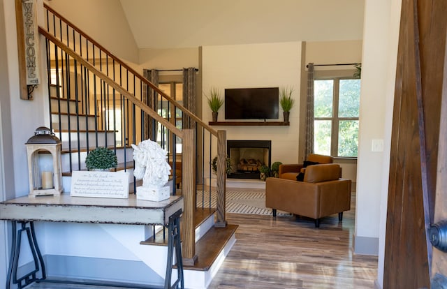 staircase with lofted ceiling and hardwood / wood-style floors