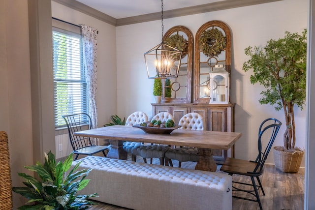 dining room with ornamental molding, hardwood / wood-style flooring, and a chandelier