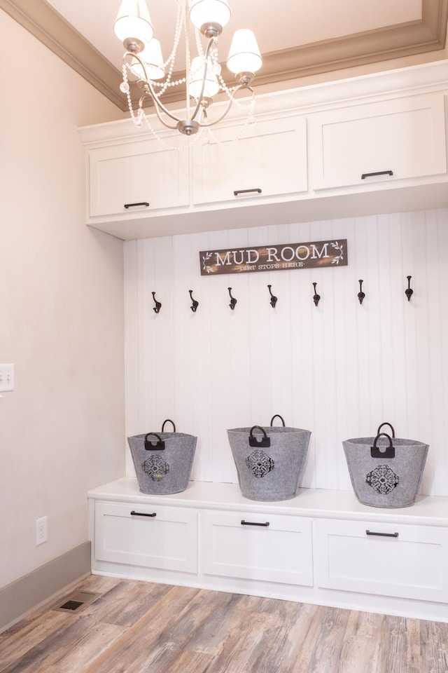 mudroom featuring crown molding, a notable chandelier, and light wood-type flooring