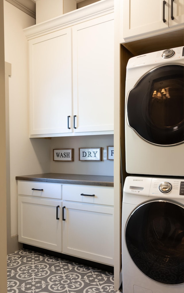 laundry room featuring cabinets and stacked washer / drying machine