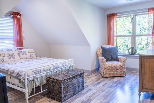 bedroom with lofted ceiling and wood-type flooring