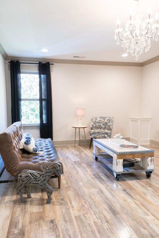 sitting room with an inviting chandelier, ornamental molding, and light hardwood / wood-style floors