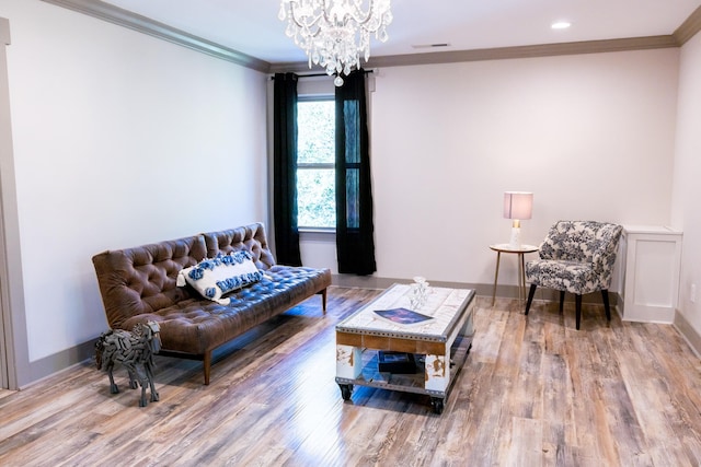 living room featuring an inviting chandelier, ornamental molding, and hardwood / wood-style flooring