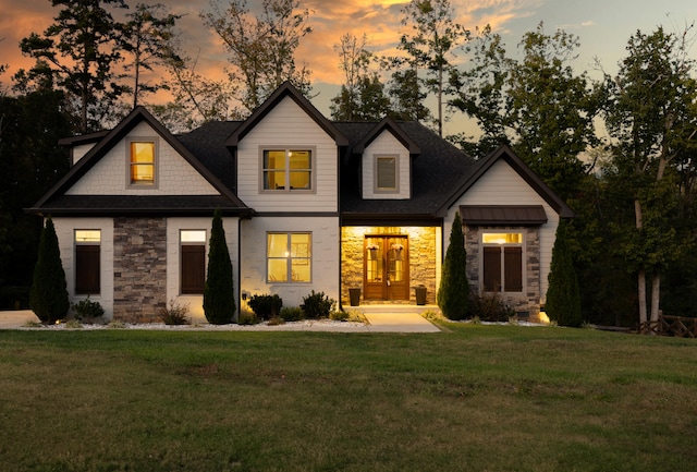 back house at dusk with a lawn