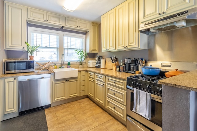 kitchen with light tile patterned floors, appliances with stainless steel finishes, and sink