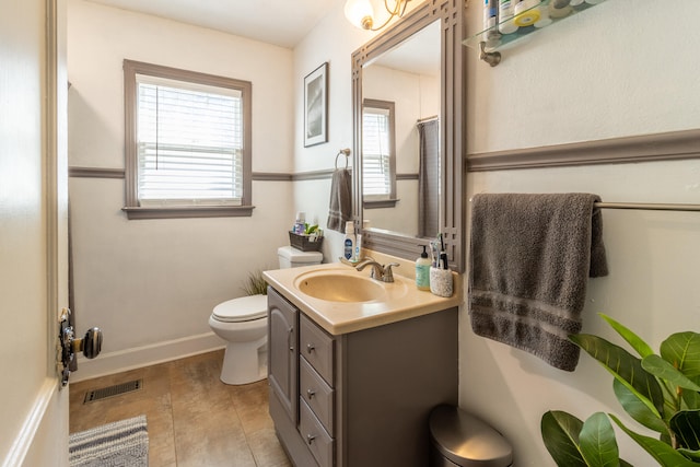 bathroom featuring vanity, tile patterned flooring, and toilet