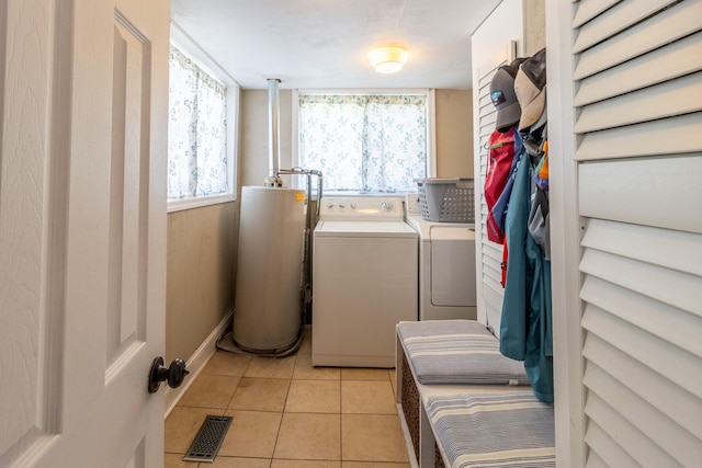 laundry area featuring light tile patterned floors, gas water heater, and independent washer and dryer