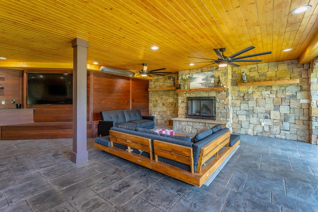 view of patio / terrace featuring ceiling fan and a stone fireplace