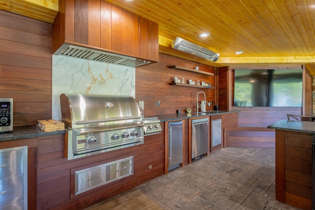 kitchen featuring wood walls, wooden ceiling, and stainless steel refrigerator