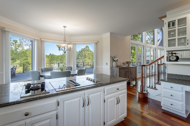 kitchen featuring stainless steel cooktop, white cabinetry, plenty of natural light, and dark hardwood / wood-style floors