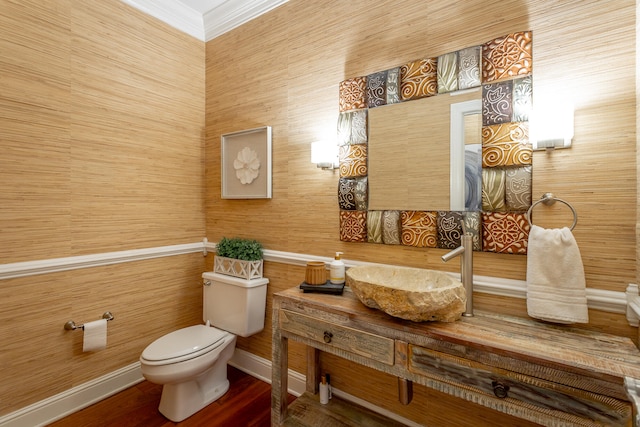 bathroom with vanity, crown molding, wood-type flooring, and toilet