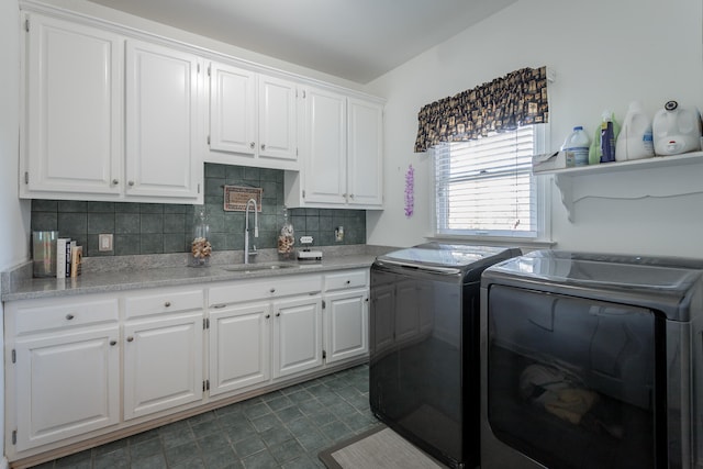 clothes washing area with cabinets, washer and dryer, and sink