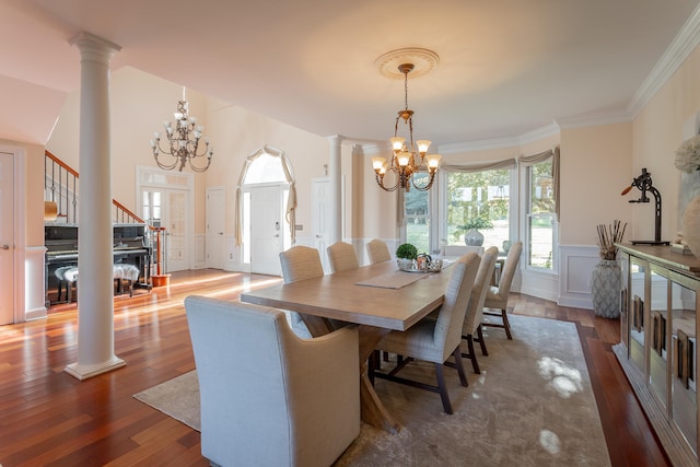 dining room with a notable chandelier, crown molding, ornate columns, and dark hardwood / wood-style floors