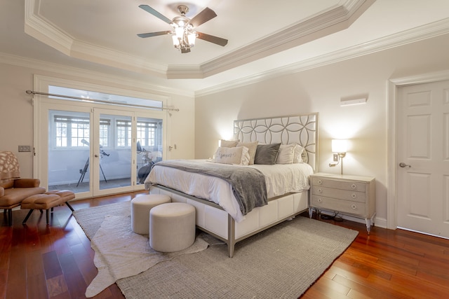 bedroom with dark wood-type flooring, a raised ceiling, access to exterior, and ceiling fan