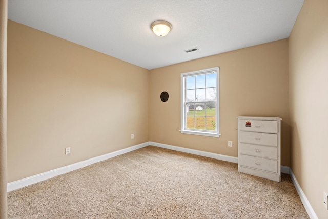 carpeted spare room with a textured ceiling